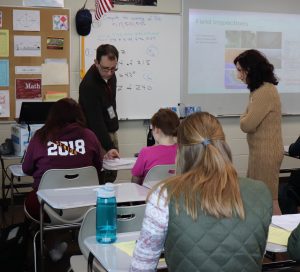 Ankeny High School teacher Joe Carey works with students after giving them an assignment based on his work last summer with InTrans' Basak Aldemir Bektas