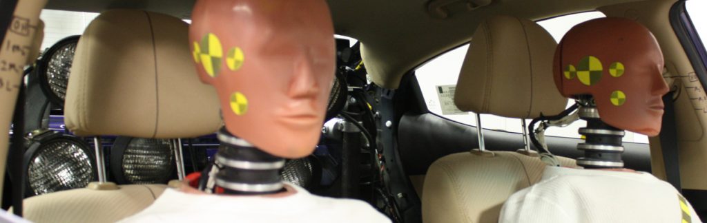 Driving dummies in the front and passenger seats of a car.