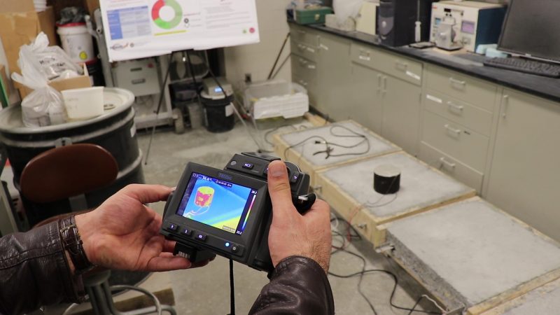 Thermal camera displaying temperature difference between electrically-conductive portion of concrete (in red) and regular concrete (in blue), demonstrated by PhD candidate Ali Arabzadeh